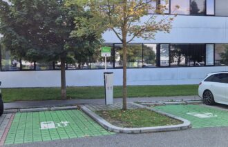 Eine Ladestation für Elektrofahrzeuge, neben der ein Auto geparkt ist.