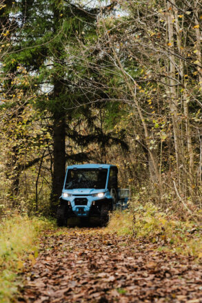 Ein blaues Nutzfahrzeug von vorne im Wald.