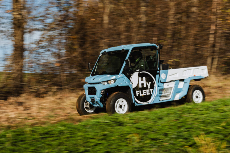 Ein fahrendes blaues Nutzfahrzeug von der Seite mit dem Schriftzug HyFleet.