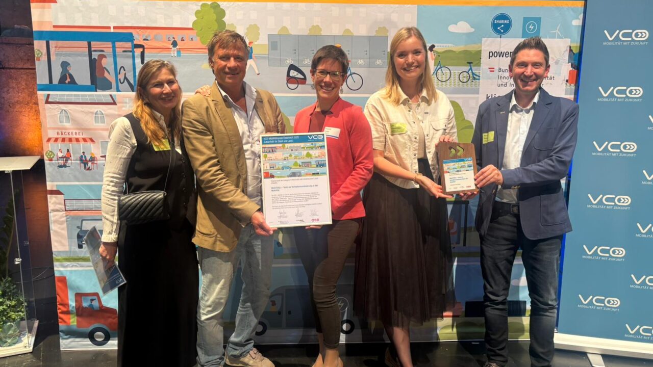 Fünf Personen halten einen Preis in der Hand und stehen vor einer Wand auf der steht "VCÖ-Mobilitätspreis Österreich - Zukunftsfit für Stadt und Land"