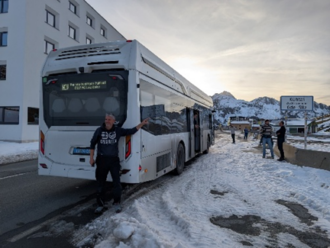 Foto eines weißen FCE-Busses von hinten, Person steht davor.