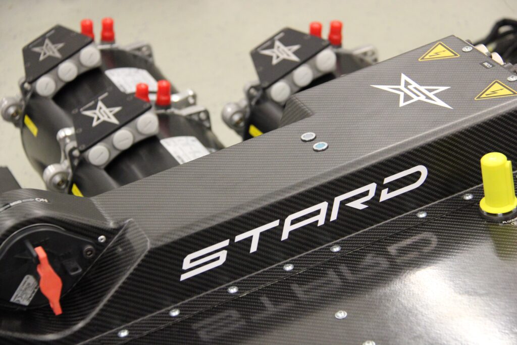 Nahaufnahme einer Kohlefaseroberfläche mit dem „STARD“-Logo und elektronischen Komponenten.