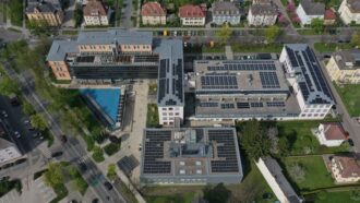 Luftaufnahme der Schulgebäudes HTL1 Lastenstraße mit angebrachten PV Modulen.