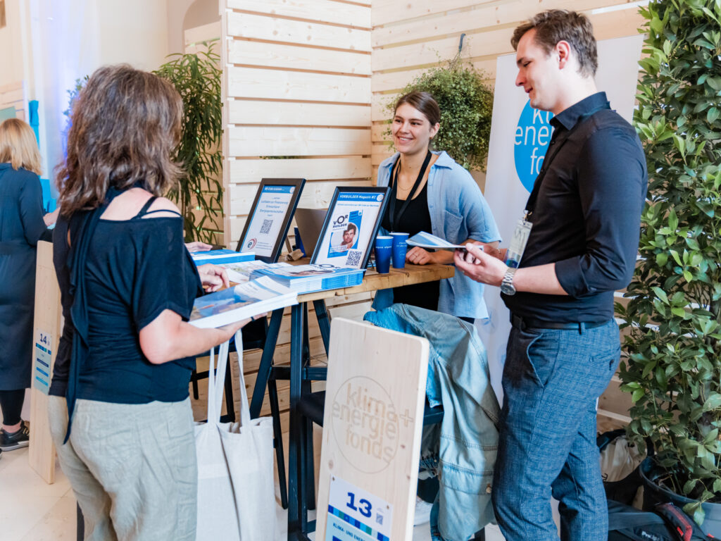 Vier Personen stehen an einem Messestand des 