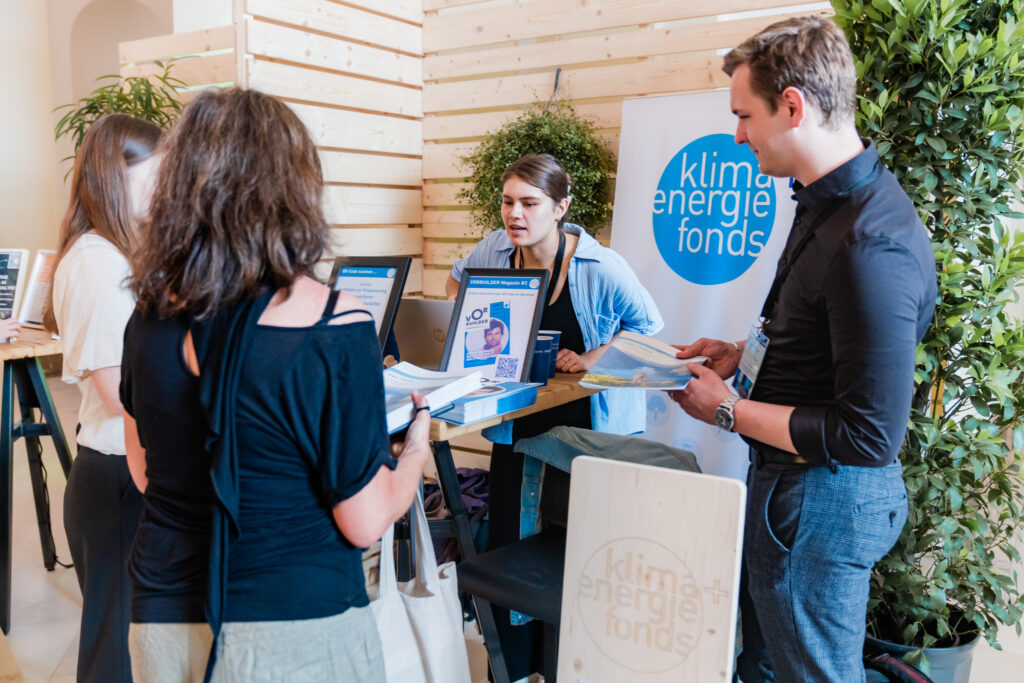 Vier Personen stehen an einem Messestand des 