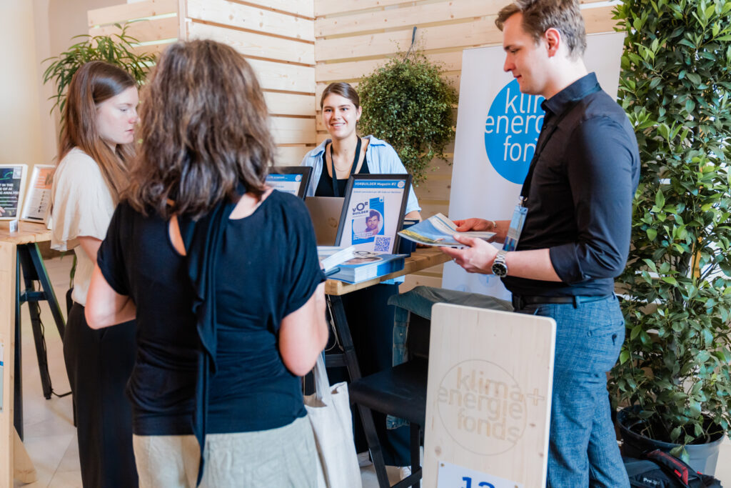 Vier Personen stehen an einem Messestand des 
