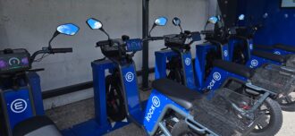 Blaue einspurige elektrische Fahrzeuge in einer Sharing Ladestation.