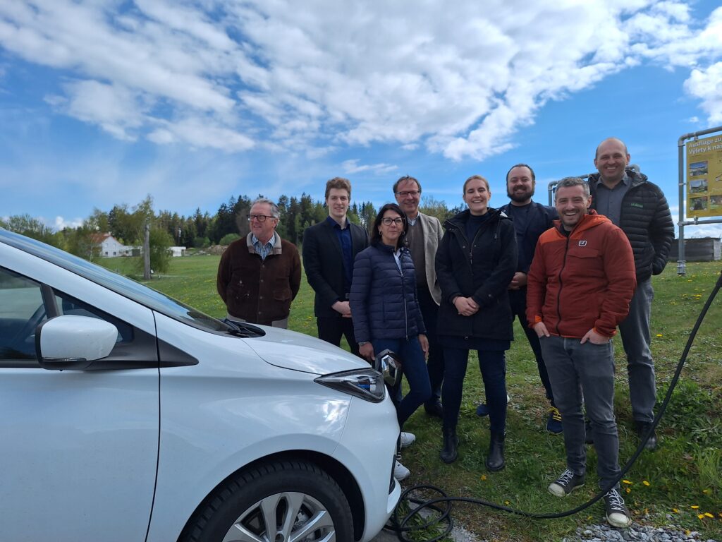 Ladendes E-Auto und 8 Menschen dahinter