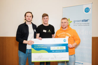 Drei Männer stehen nebeneinander und halten gemeinsam einen übergroßen Scheck in die Kamera. Der Scheck zeigt die Aufschrift „TerraBreeze by Social Cooling“ und den Betrag „EUR 20.000,-“ für die Auszeichnung als „TOP-3 GREENSTART 2024“. Im Hintergrund steht ein Roll-up-Banner mit dem Logo und Slogan der „greenstart“-Initiative des Klima- und Energiefonds Österreichs. Alle drei Männer lächeln und blicken direkt in die Kamera.