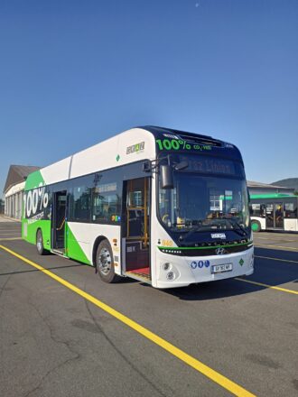 Elektrobus in einer Haltestelle mit „100% CO2-frei“-Schriftzug und Logo der Graz Linien, Hintergrund klarer Himmel.