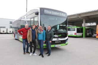 Foto Projektleitung OptichargE vor Elektrobus mit Zielschild 