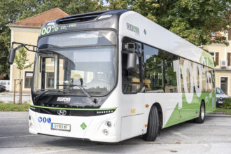Grün-weißer öffentlicher mit Wasserstoff betriebener Bus mit großen Schriftzeichen "100% CO2-FREI"