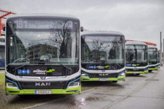 Vier geparkte Elektrobusse mit beleuchteten Zielschildern