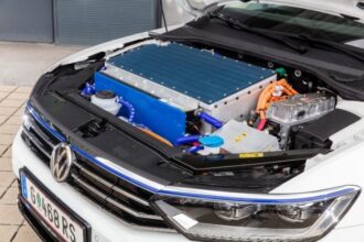 Motorraum eines Elektrofahrzeugs mit Batterie und Motor unter der offenen Motorhaube.