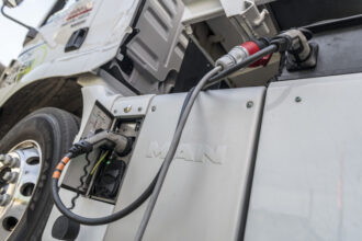 Elektrokabel zum Aufladen eines MAN-Lastwagens, Fokus auf Ladestecker und Steckdose.