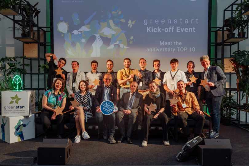 Gruppe von 15 Personen auf Bühne bei greenstart Kick-off Event, einige halten Sterne als Auszeichnung, Hintergrund zeigt Eventtitel und Slogan
