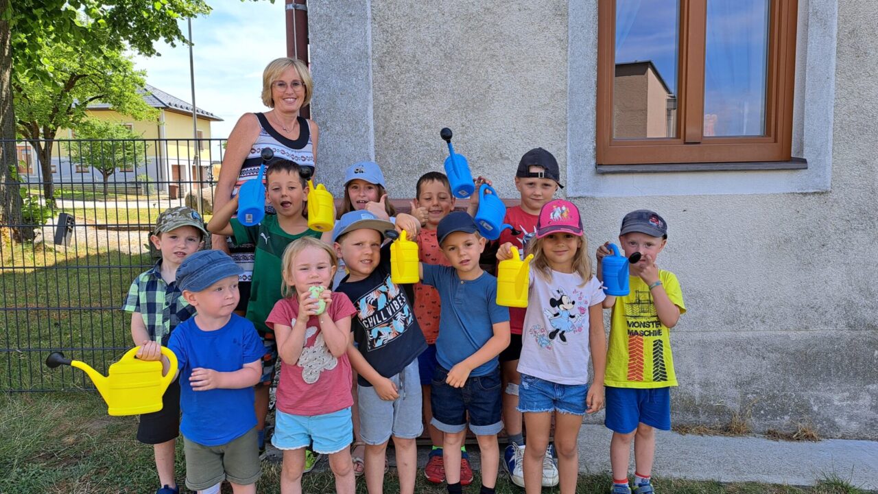 Kindergartenkinder mit Gießkannen