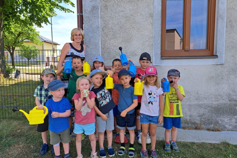 Kindergartenkinder mit Gießkannen