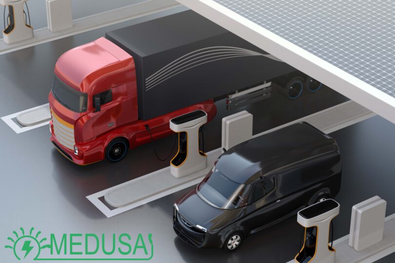 Man sieht einen LKW sowie einen PKW an einer E-Ladesäule.