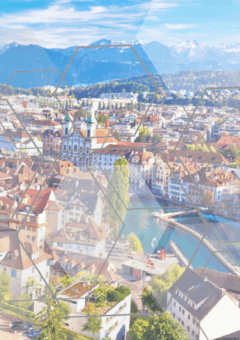 Panoramablick auf eine Stadt mit Fluss, Brücken und Bergen im Hintergrund, überlagert von transparenten sechseckigen Mustern
