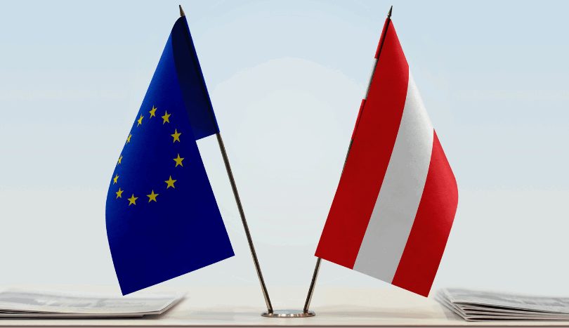 Eine kleine europäische und eine kleine österreichiche Fahne auf einem Tisch.