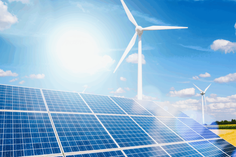 Es ist eine Solarpanele und ein Windrad unter strahlendem Sonnenschein zu sehen.