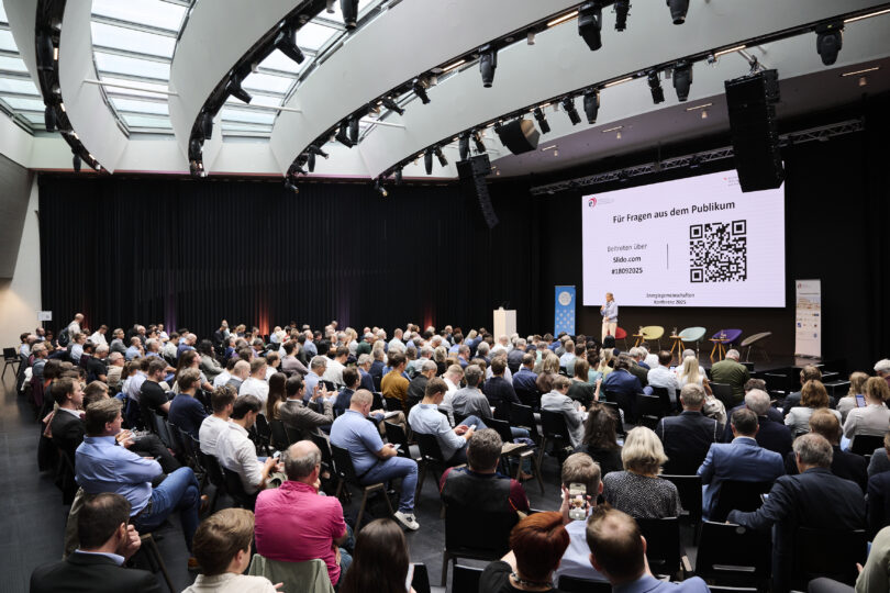 Energiegemeinschaften Konferenz 2025: Foto vom Saal mit ca. 350 Personen und die Moderatorin auf der Bühne
