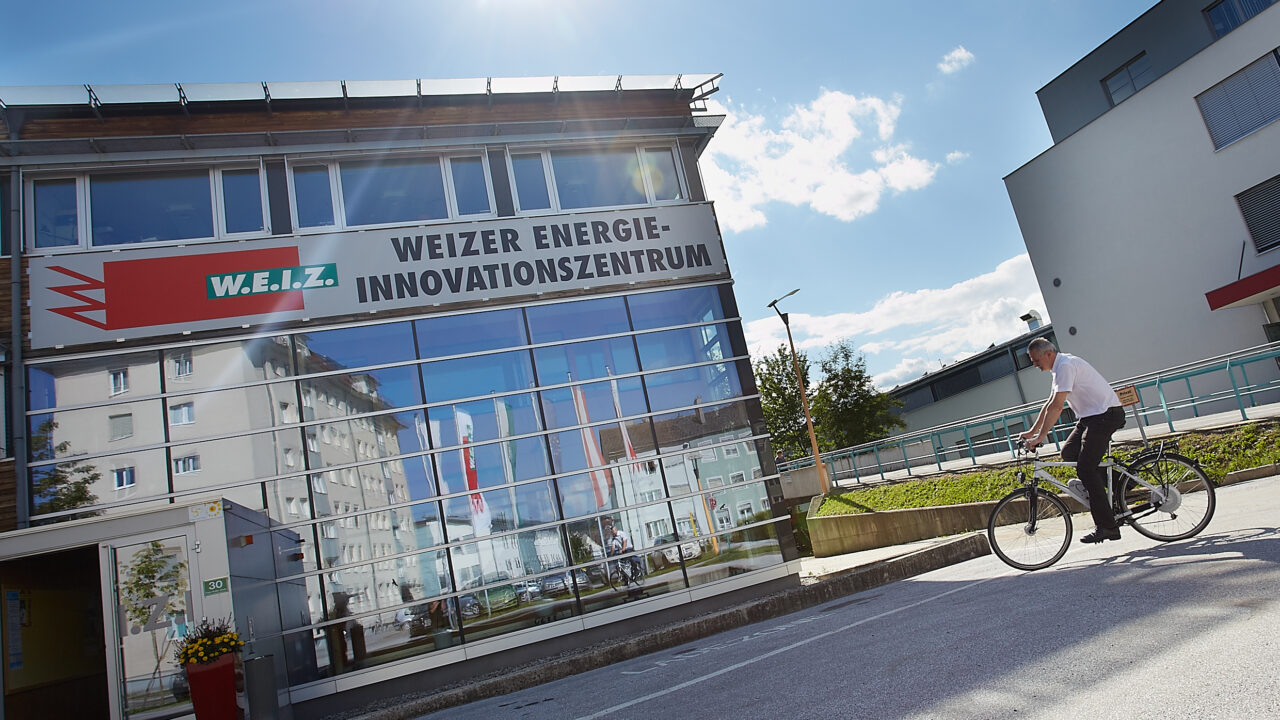 Fahrradfahrer vor dem Weizer Energieinnovatonszentrum