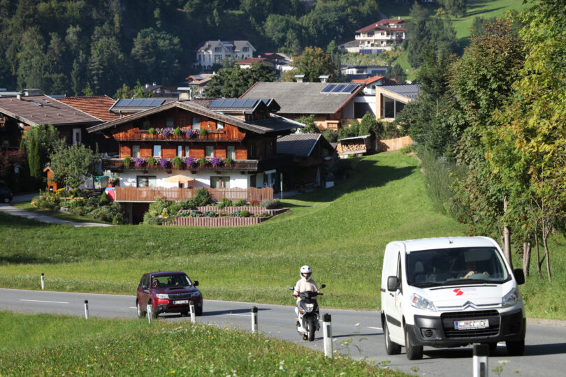 Zwei Autos und ein Motorrad auf der Straße im wunderschönen Tirol.