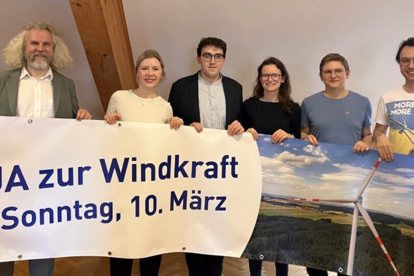 Menschen vor Plakat zur Windkraft