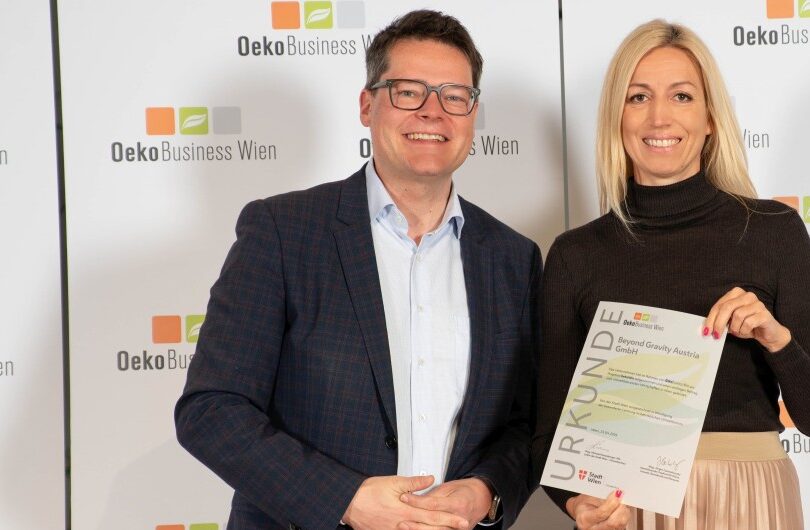 Ein Mann und eine Frau, die Frau hat eine Urkunde in der Hand