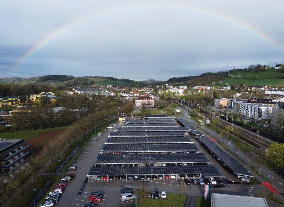Parkplatz mit PV-Überdachung in Landschaft mit Regenbogen
